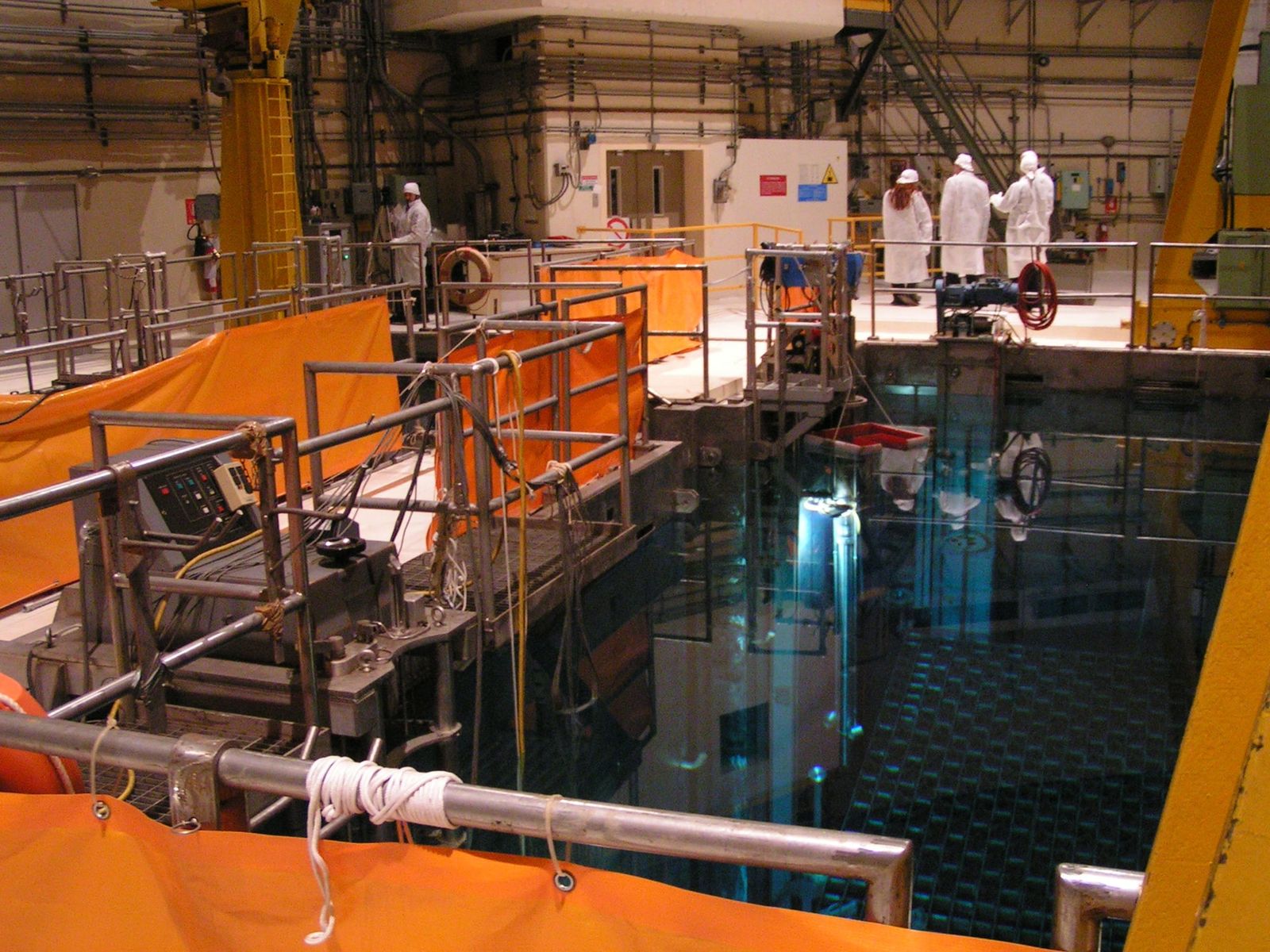 Metal assemblies undergo cooling in storage pools before mechanical disassembly, a crucial step in extracting remaining energy from nuclear fuel.